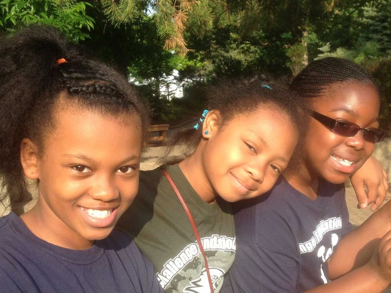 Three girls posing for picture during school zoo outing