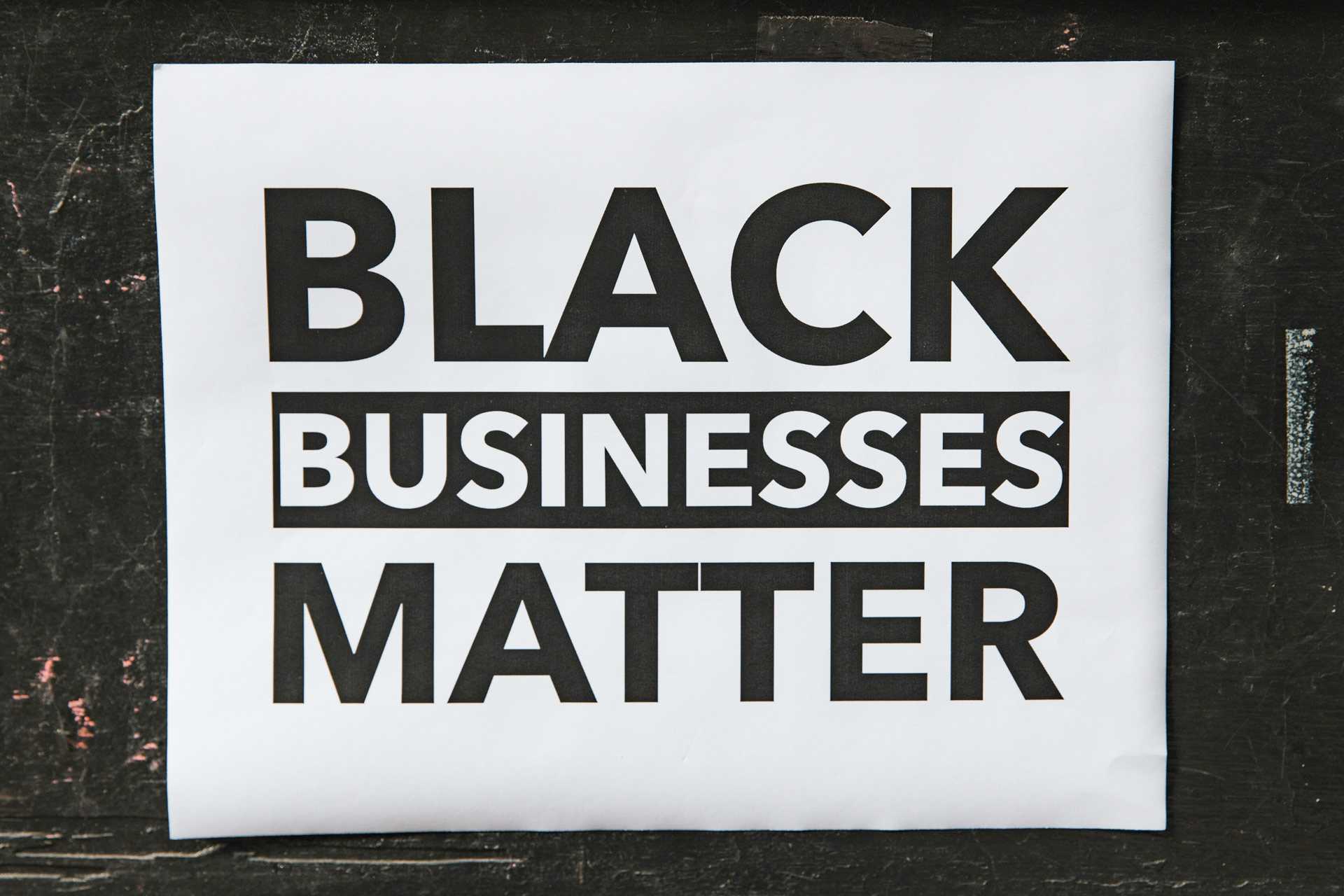 sign on black wall says “Black Businesses Matter”