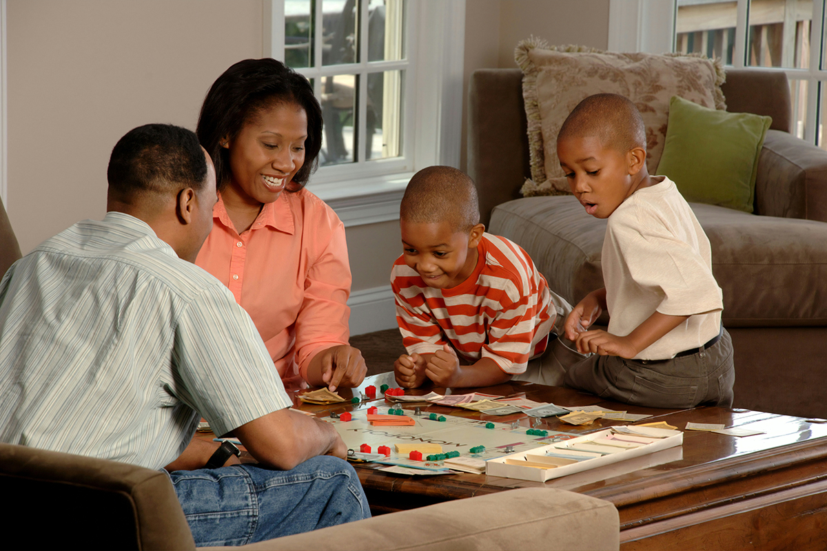 family with two young children playing board game