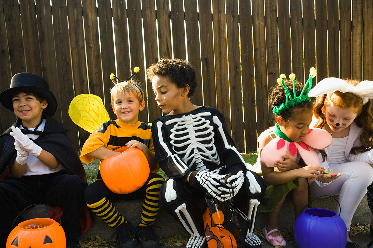 Kids in Halloween costumes looking through their candy